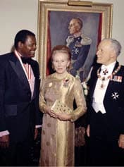 Jazz pianist Oscar Peterson (left) receives the Order of Canada from Roland Michener (right), the 20th Governor General, in 1973. In the centre are Norah Michener and a portrait of Vincent Massey, the 18th Governor General.